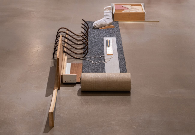 עבודתה של עדן בנט היא מיצב המורכב מקטעי פיסול רצפה הכוללים מפתים תעשייתיים וחפצי בית