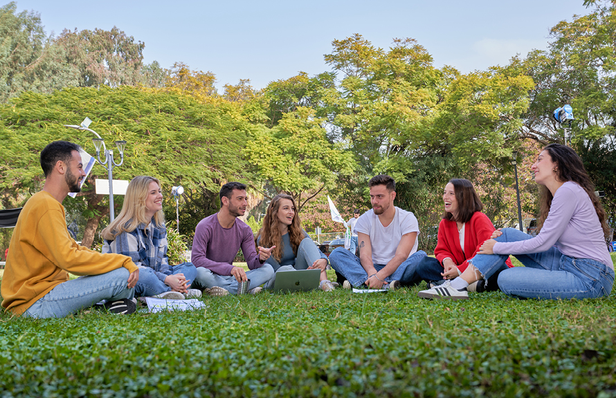 סטודנטים לתואר ראשון יושבים בדשא 