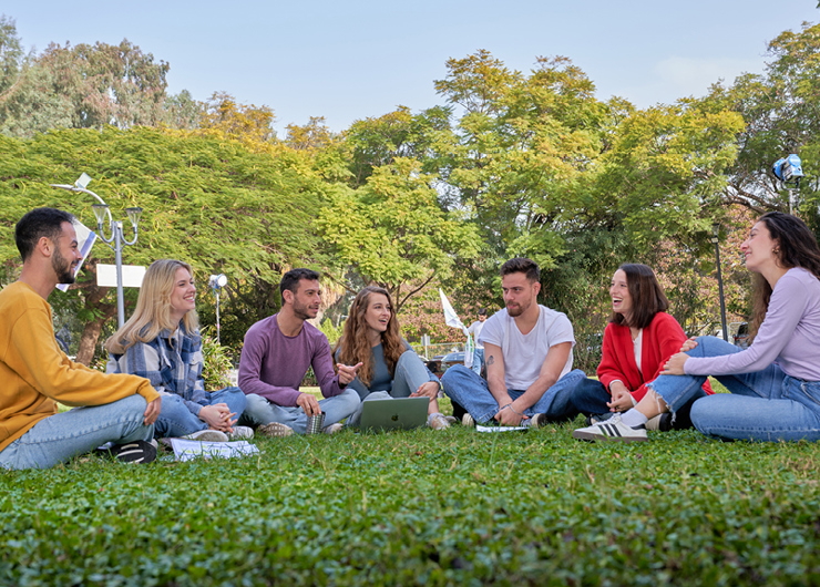 סטודנטים לתואר ראשון יושבים בדשא 
