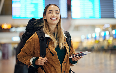 סטודנטית מחייכת בשדה תעופה לפני משלחת לימודים בחו"ל 