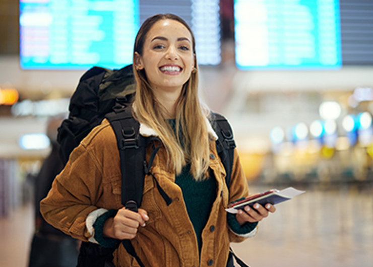 סטודנטית מחייכת בשדה תעופה לפני משלחת לימודים בחו"ל 